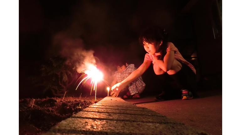 Boy and girl playing with fireworks