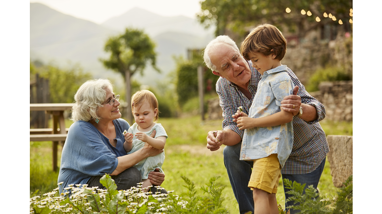 Grandparents talking to children in yard