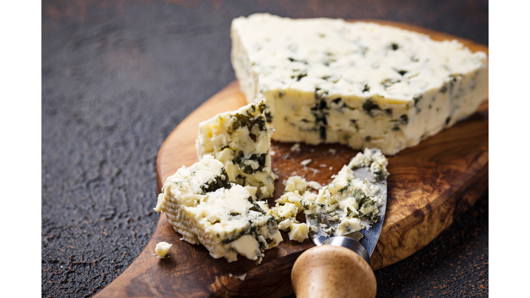 Blue cheese and knife on cutting board