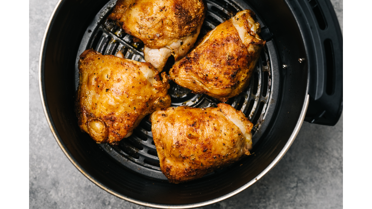 Four spicy air fried chicken thighs in an air fryer