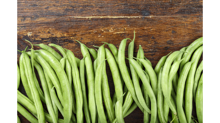 fresh green beans on a wooden background.