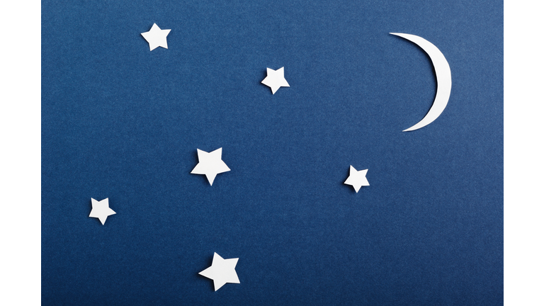 Moon and stars on blue background top view. Night sky objects with shadow close up. Decorative backdrop. Childish applique, homemade postcard. Starry heaven. Kid bedtime, nighttime concept.