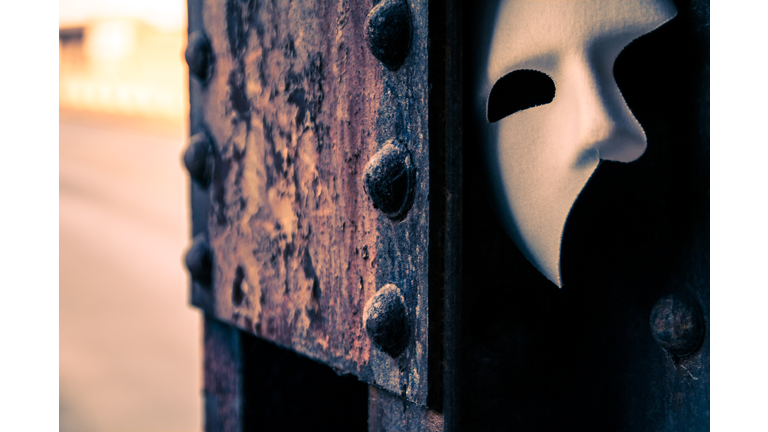 Phantom of the Opera mask on a dark gritty retro vintage steel bridge