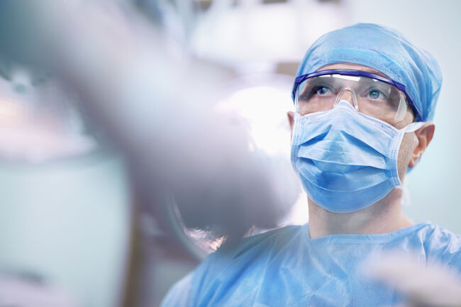 Nurse giving tools to surgeon in operating room