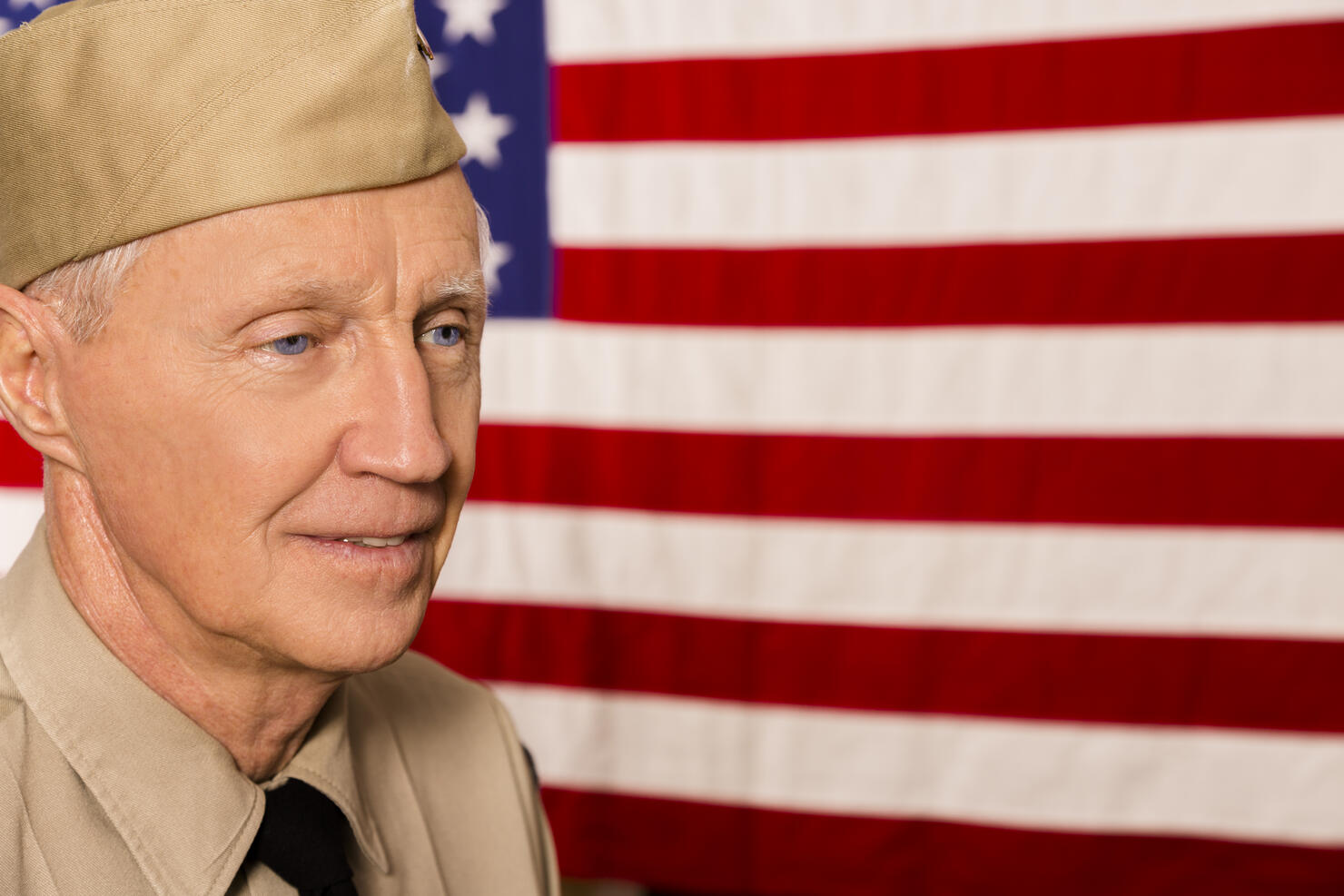Military: Senior veteran in uniform with American flag.