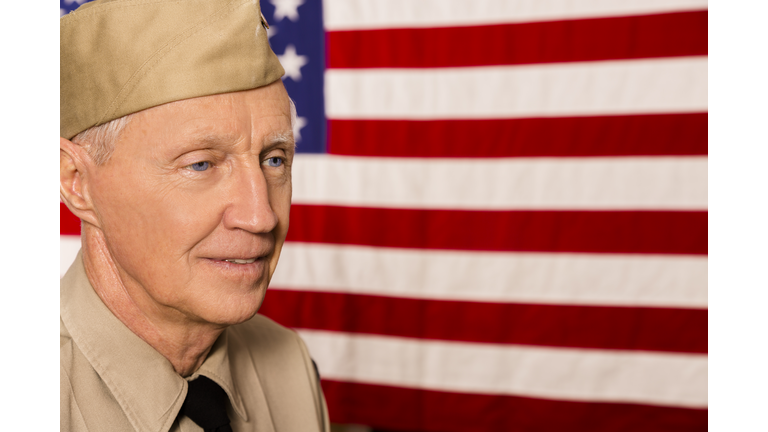 Military: Senior veteran in uniform with American flag.