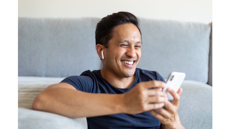 Man smiling during a video call on his cell phone at home