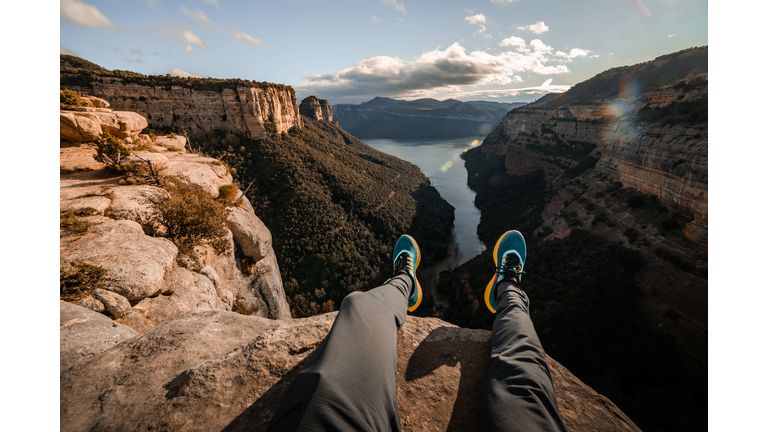 Stunning view from personal perspective in rocky mountains sitting on the edge.