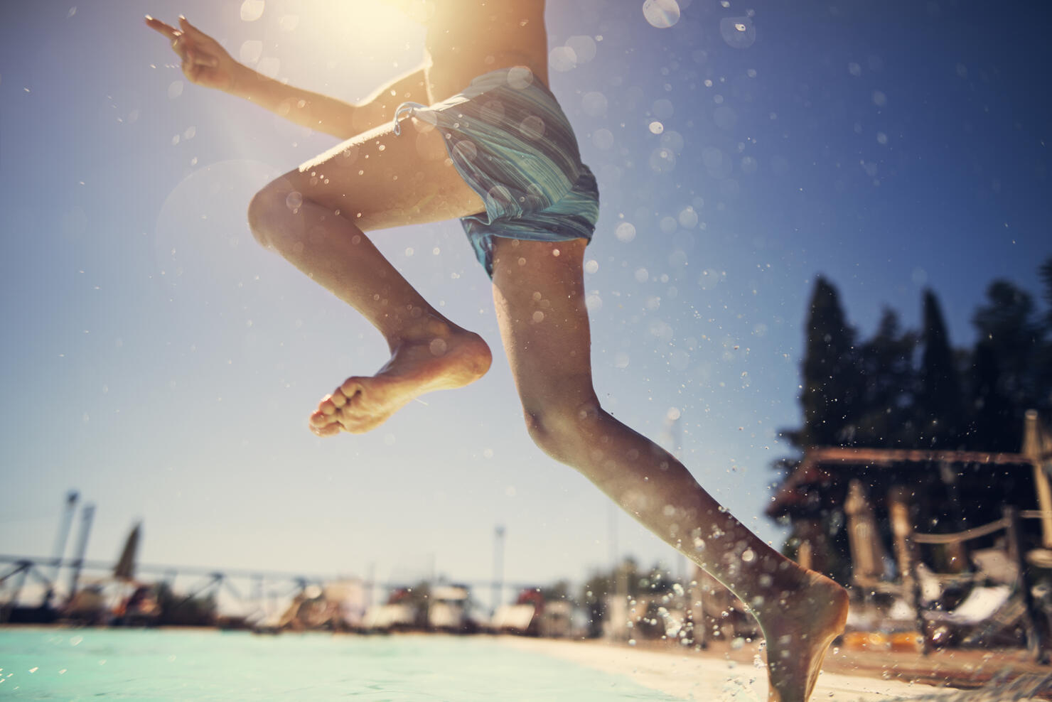 Little boy jumping into swimming pool