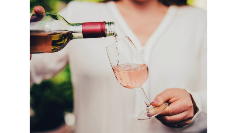 Woman pouring wine in glass.