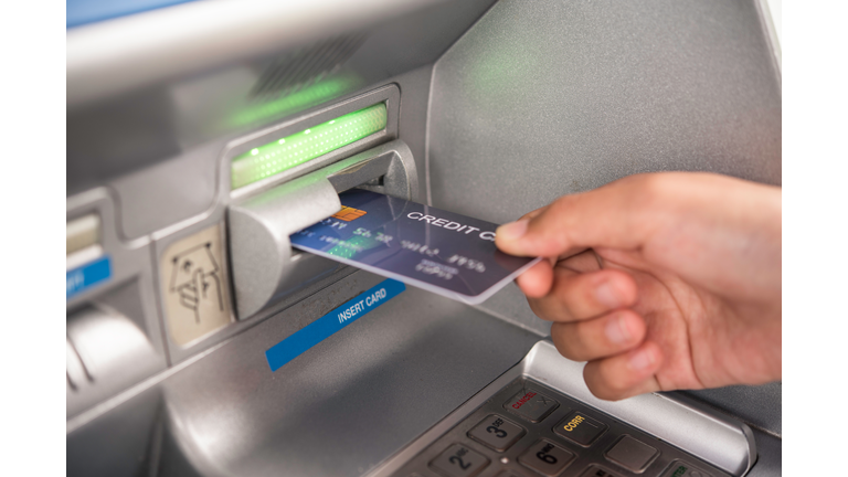 Cropped Hand Inserting Credit Card In Atm Machine