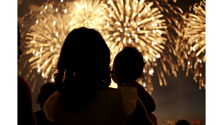 Silhouette of mother and daughter watching fireworks