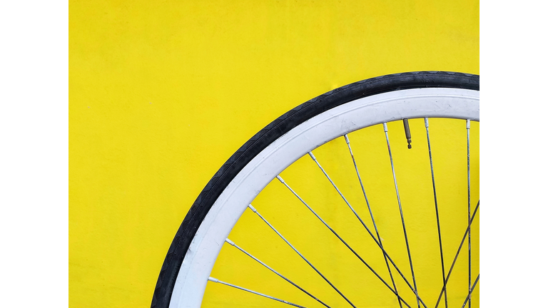 Close-Up Of Bicycle Wheel Against Yellow Background