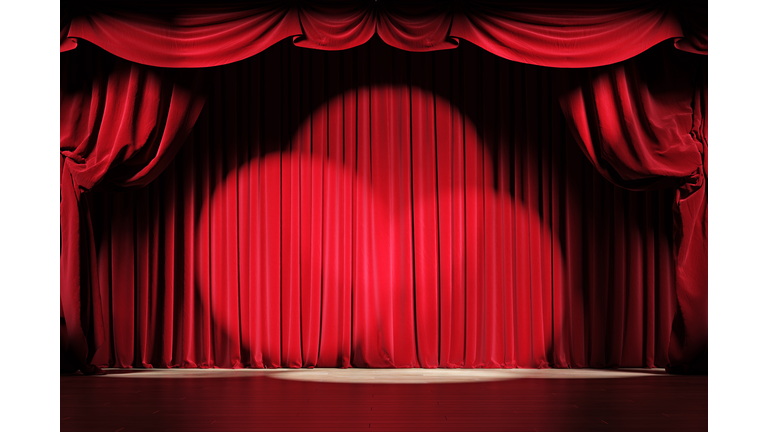 Theater stage with red velvet curtains and spotlights.