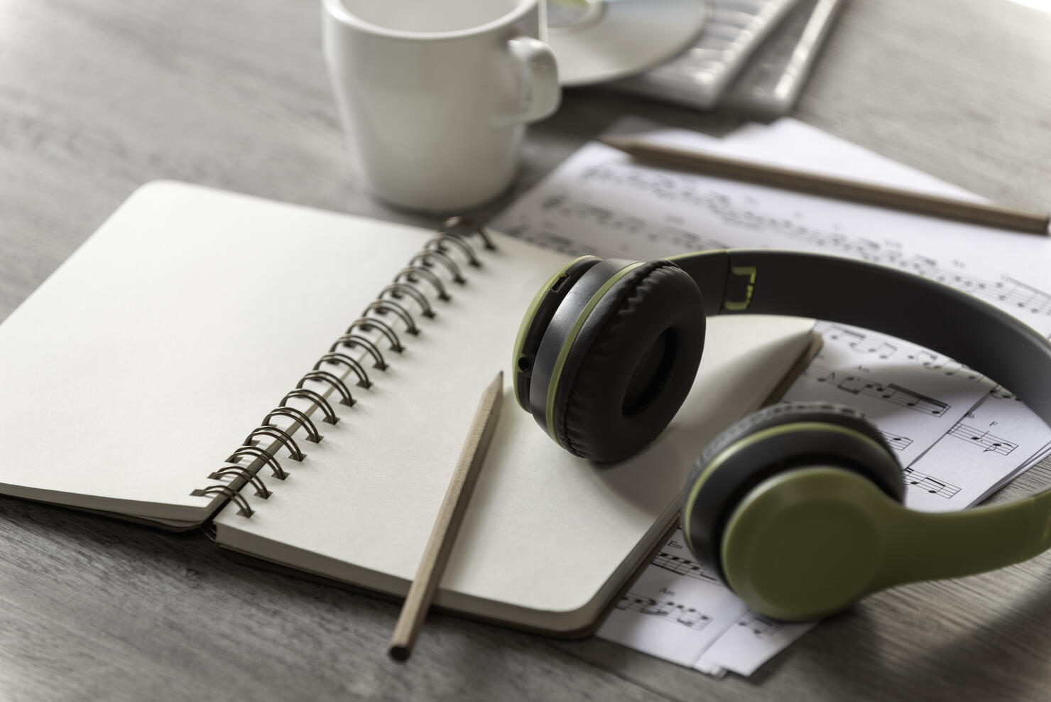 Paper notebook, pencil and earphone with note music paper on the table,Music writer concept, song writer,