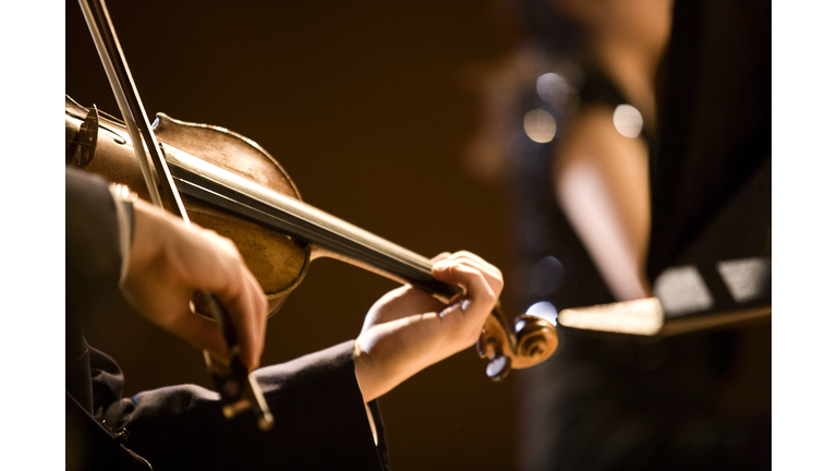 The girl's hand on the strings of a violin