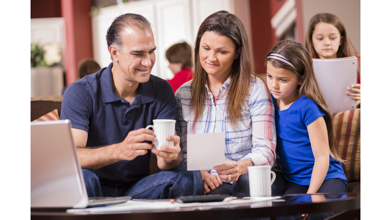 Budget.  Family of five together at home.  Mixed races.