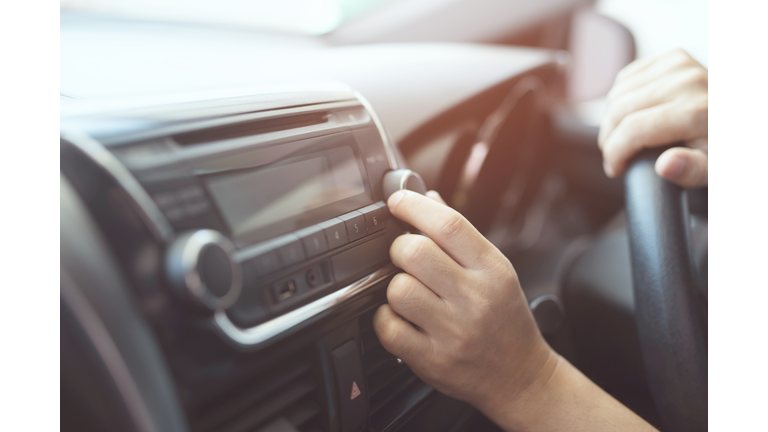 close up hand open car radio listening. Car Driver changing turning button Radio Stations on His Vehicle Multimedia System. Modern touch screen Audio stereo System. transportation and vehicle concept