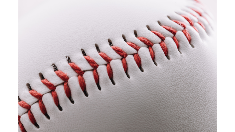 Close-up of a red thread seam on a white leather baseball