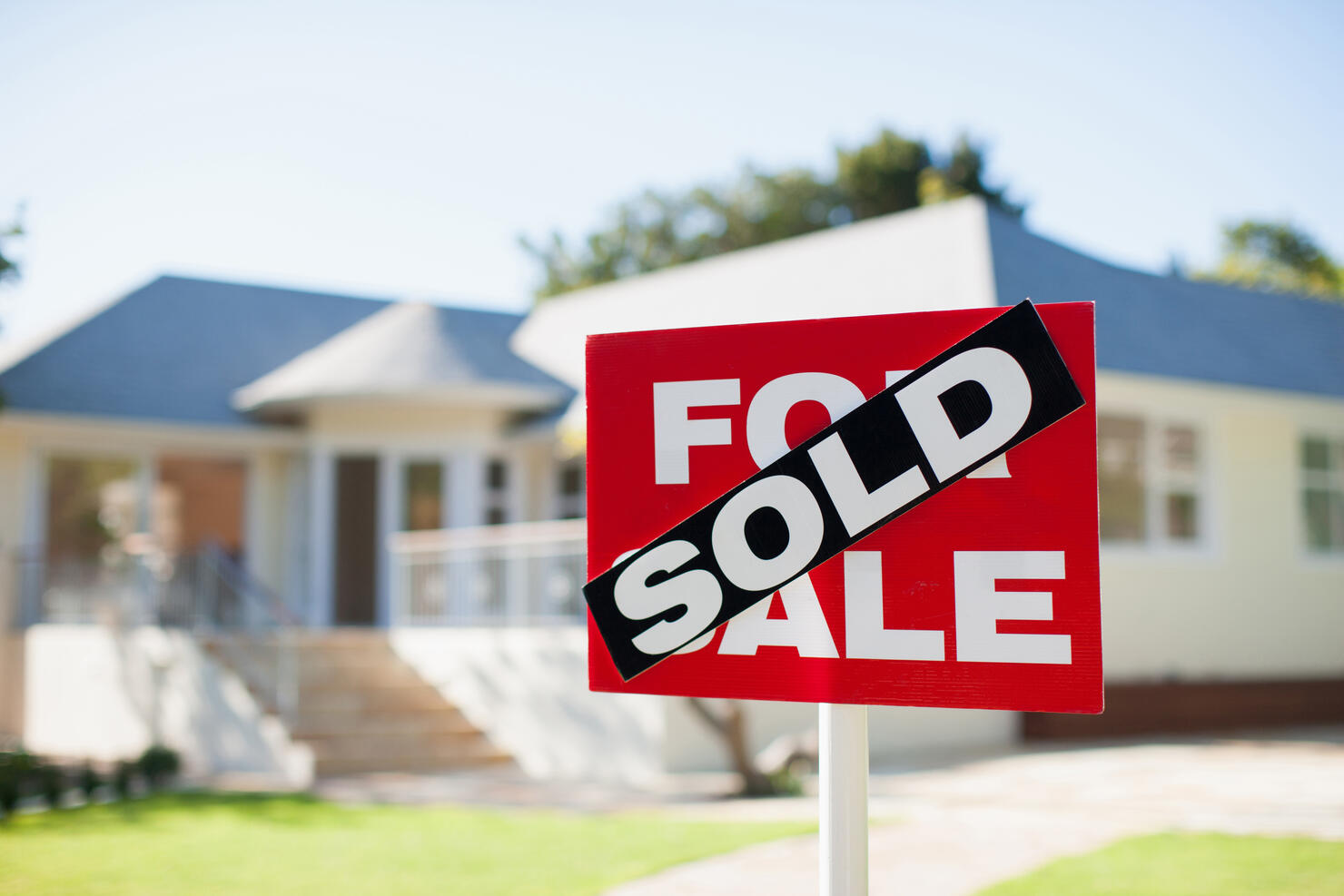 For sale sign in yard of house