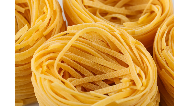 dried italian pasta, fettuccine nests, abstract food background, closeup shot