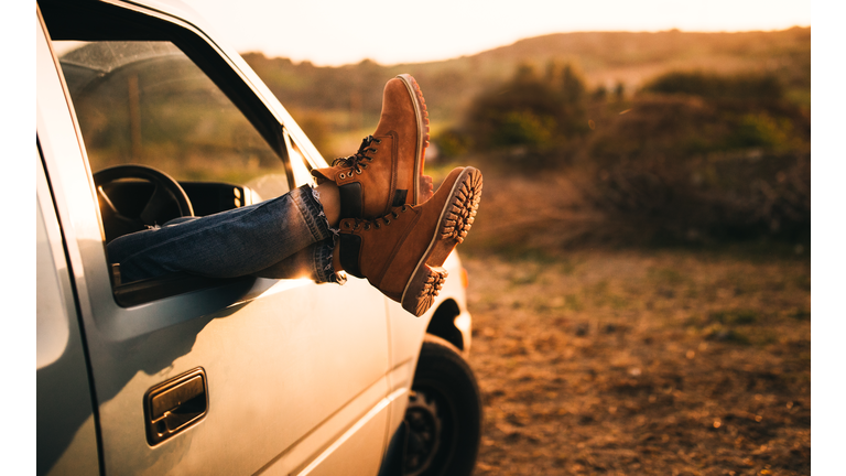 Female legs sticking out of a pick-up truck window