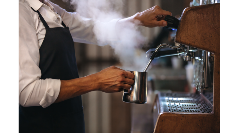 Barista making a cup of coffee in machine