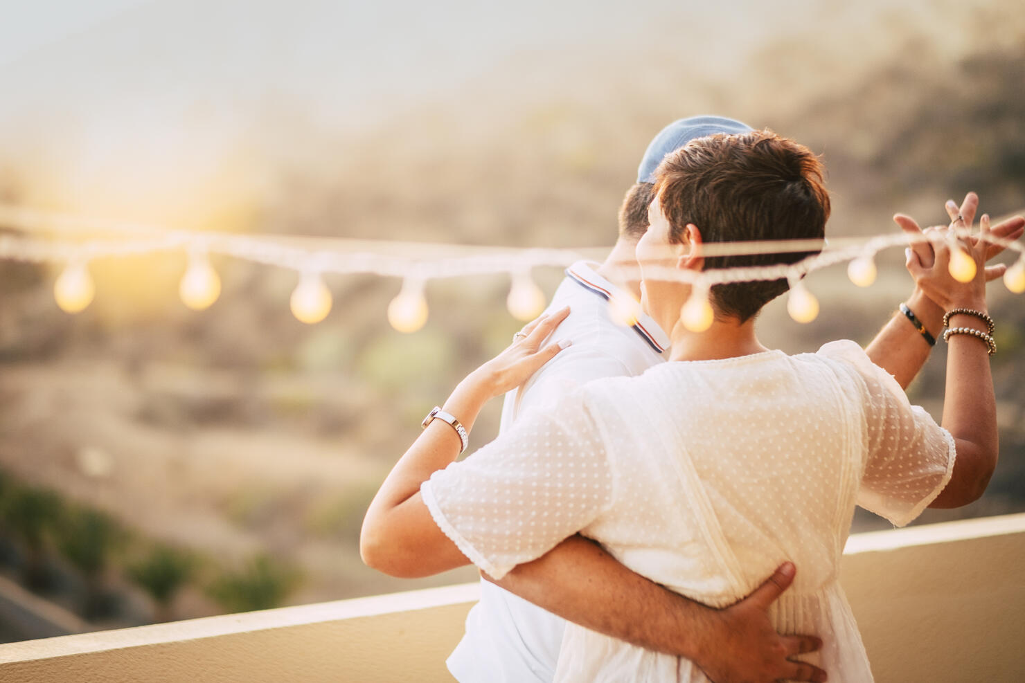 beautiful couple dancing on the terrace rooftop with natural view. love and dating concept for people having romantic leisure activity together with love and tenderness. foreverness concept and sunset time