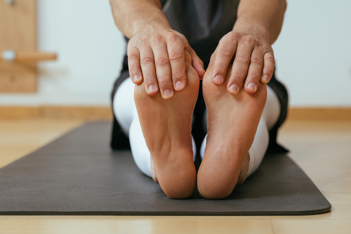 Sportsman Doing Stretching Exercise on the Floor
