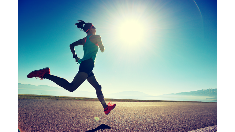 young fitness woman runner running on sunrise seaside trail