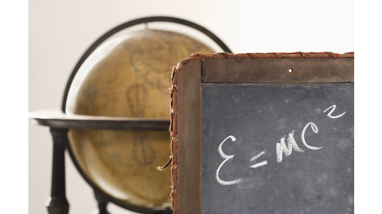 Antique slate with Einstein equation and globe