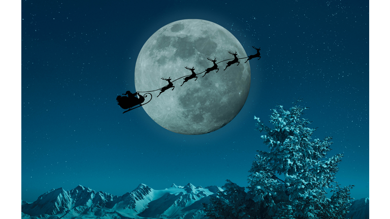 Silhouette of Santa and reindeer flying sleigh near full moon