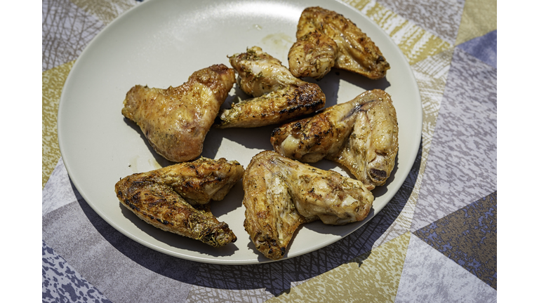 Spicy chicken wings grilling on a plate.