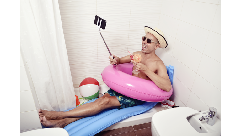 man with swim ring taking selfie in the bathroom