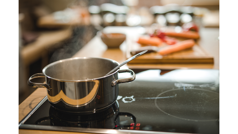 Cooking pan with boiling steam on a stove.