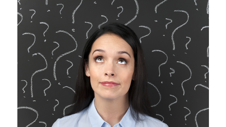 Woman with question marks on a blackboard