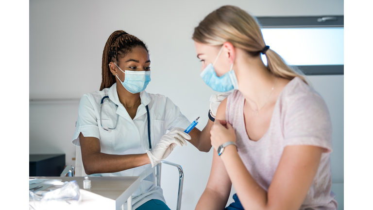 Woman with face mask getting vaccinated, coronavirus concept.