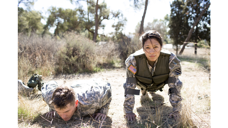 Army woman and man doing pushups