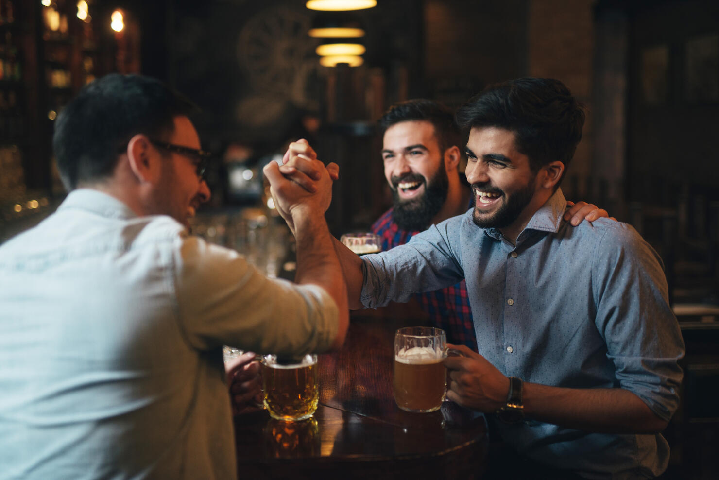 Men watching football in bar and drink beer