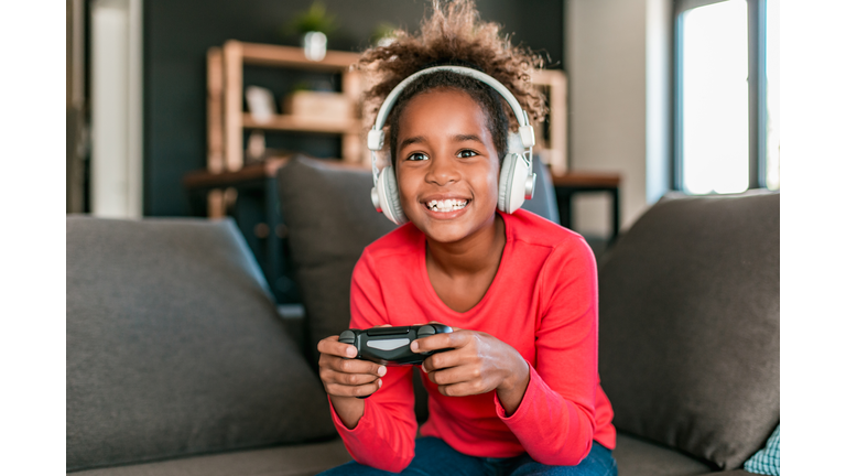 Young girl playing video games at home