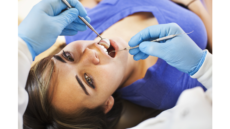 Dentist examining patient's teeth