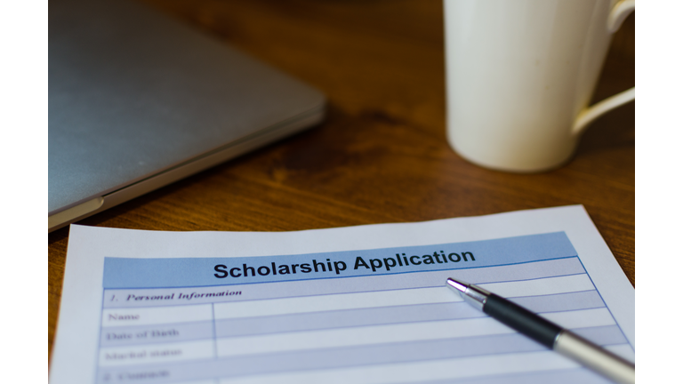 Close-Up Of Scholarship Application Form With Pen On Table