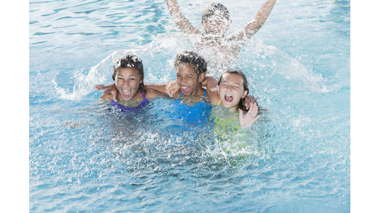 Children splashing in swimming pool.