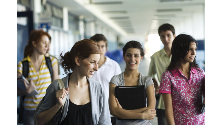 High school students walking along school corridor together