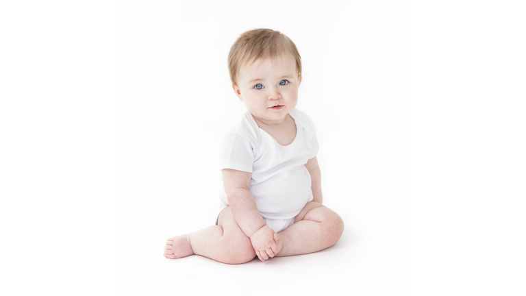 Seated baby girl looking across to camera