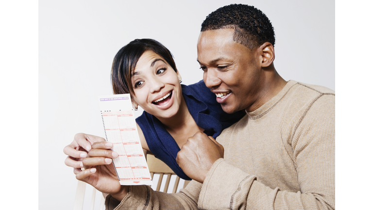 Excited couple looking at lottery ticket