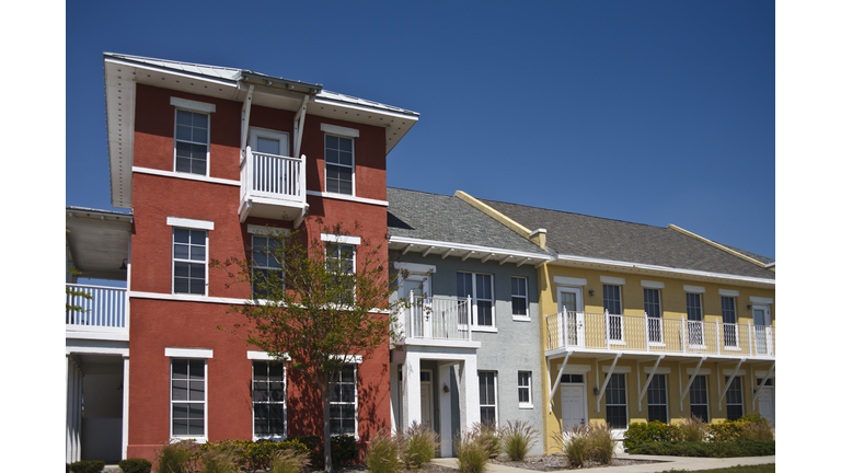 A colorful affordable housing complex under a clear sky