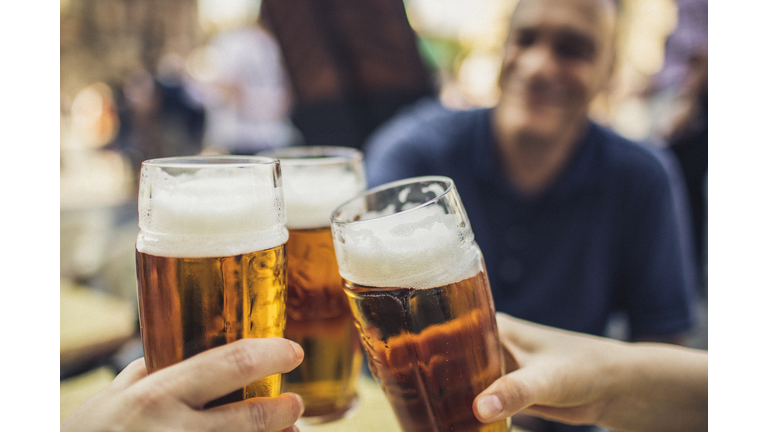 In Prague, three friends cheering on good news with glasses of pilsner beer.