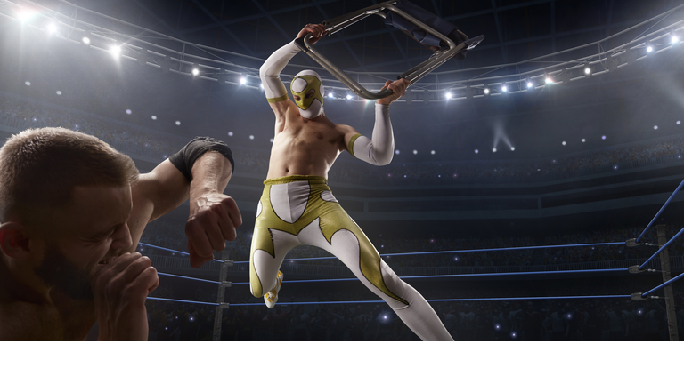 Wrestling show. Two wrestlers in a bright sport clothes and face mask fight in the ring