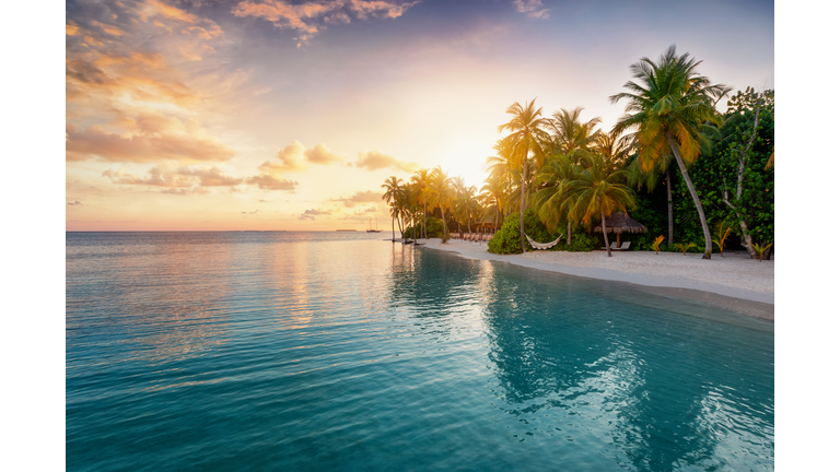 Sunrise behind a tropical island in the Maldives